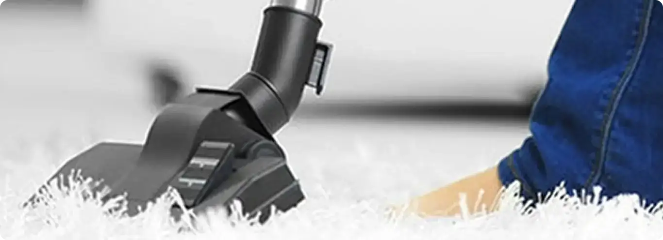 Close-up of a professional vacuuming a white carpet in Bethlehem.